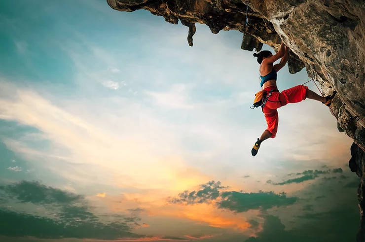 A rock climber poised on the edge of a cliff